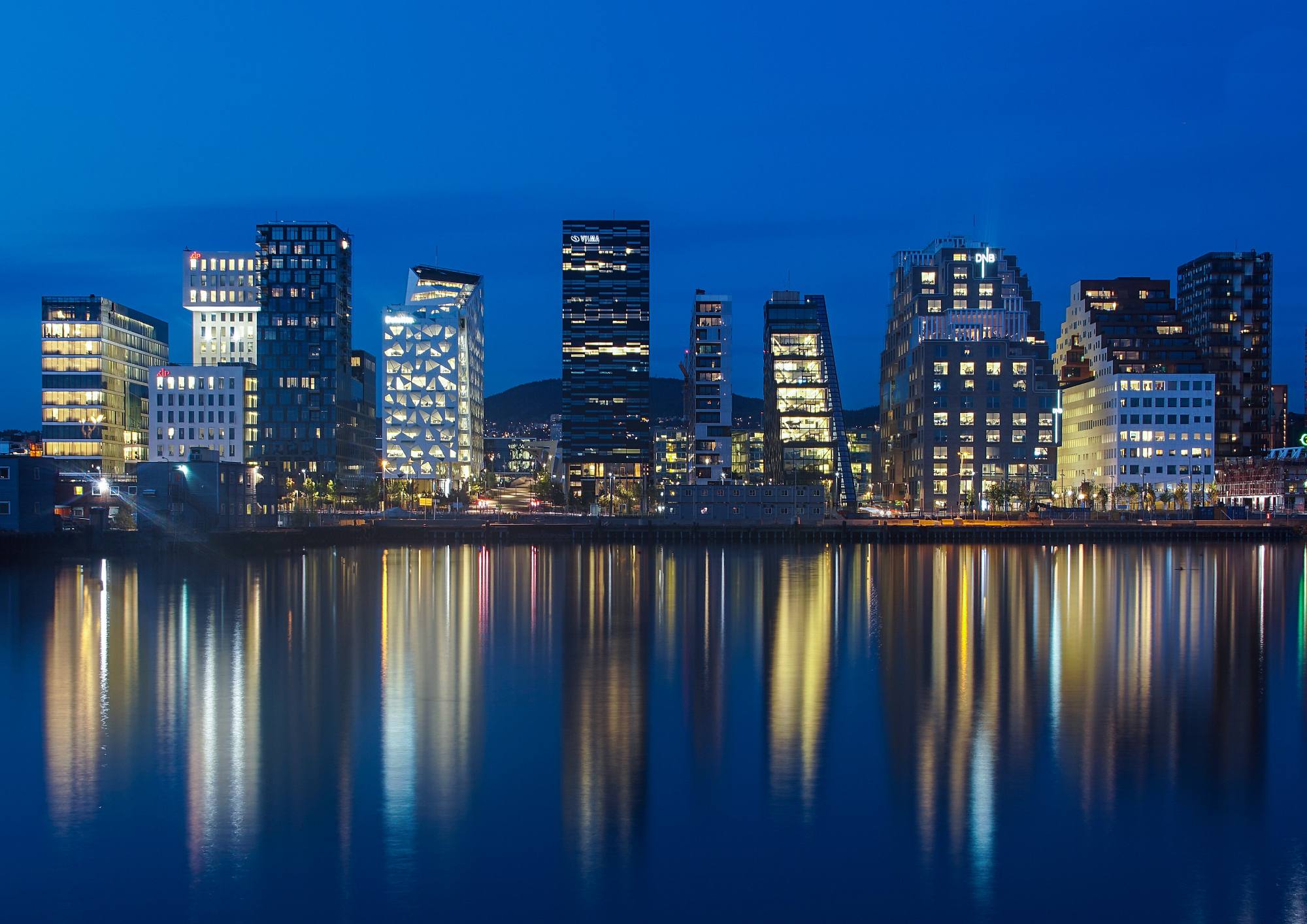 Office buildings in Bjørvika, Oslo, at blue hour, mirrored in the fjord