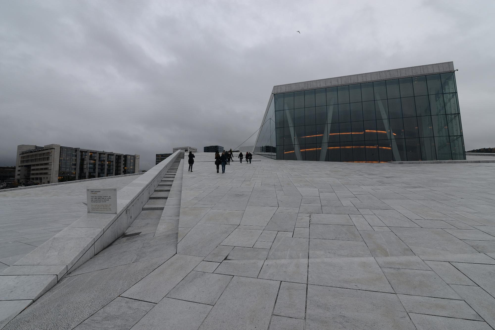 The marble roof of the Oslo Opera House, with people walking up the slope